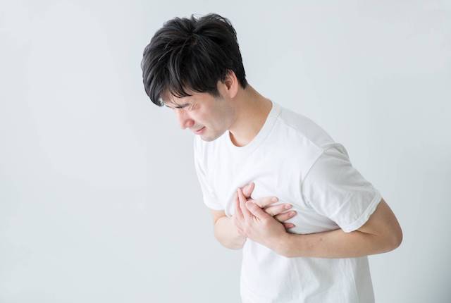 胸をおさえる男性