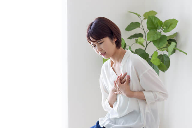 胸をおさえる女性